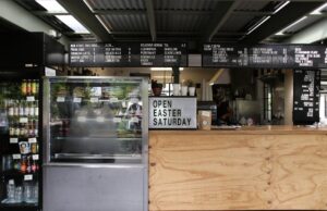 thi công trần thạch cao chống cháy giá rẻ long điền | A trendy café interior featuring menu boards, a display case, and a woo