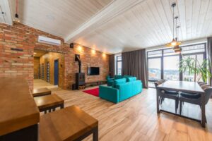 thi công trần thạch cao đơn giản giá bao nhiêu nhơn trạch | Spacious modern living room featuring a brick wall, teal sofa, an
