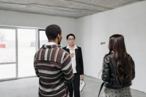 thi công vách thạch cao chuyên nghiệp phước tỉnh long điền | Realtor showing young couple a house, discussing details inside