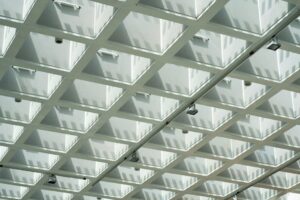 báo giá báo giá vách thạch cao phú mỹ | Abstract geometric ceiling design with textured shadows and grid pattern.