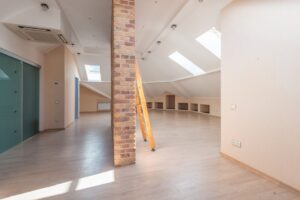 báo giá làm vách thạch cao phú mỹ | Spacious attic room with natural light from skylights, featuring a brick pillar and a woo