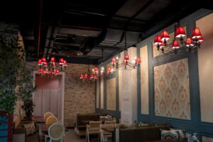 báo giá thi công trần thạch cao nhà phố vũng tàu | Stylish cafe interior in Erbil featuring red chandeliers, classic furnitur