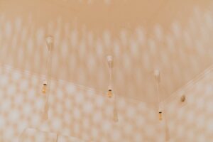 báo giá làm vách thạch cao hồ cốc | Minimalist ceiling featuring multiple hanging light bulbs creating intricate shadow patte