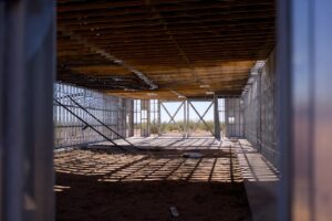 báo giá thi công trần thạch cao chống ẩm đất đỏ | Interior view of a construction site with metal framing and wooden ceiling,