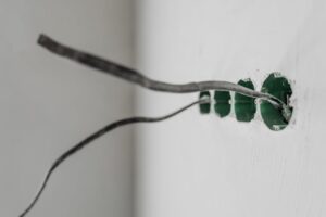 báo giá thi công trần thạch cao đơn giản châu đức | Unfinished electrical outlet installation with exposed wires on a white w