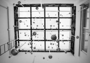 báo giá thi công vách thạch cao ngãi giao | Black and white view of a modern art installation with suspended spheres viewed f