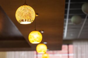 báo giá trần thạch cao giá bao nhiêu phước bửu | Close-up of golden pendant lamps hanging in a modern indoor setting, creatin