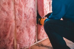 báo giá vách thạch cao chuyên nghiệp đất đỏ | Crop unrecognizable worker in gloves sitting on haunches and insulating with pi