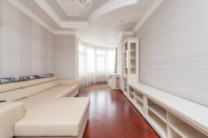 báo giá vách thạch cao ngãi giao | Bright and spacious minimalist living room with modern furniture and wooden flooring.